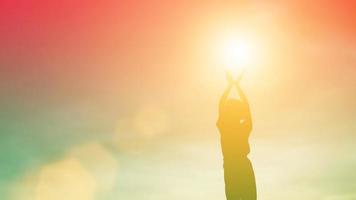 Silhouette of woman praying over beautiful sky background photo