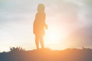 silueta de niños felices y puesta de sol feliz foto