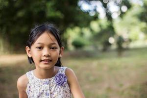 Little cute asian girl standing among the purple flower field sunshine day. Freedom enjoying with nature. photo