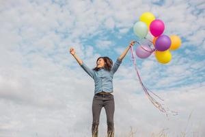 Beautiful Girl jumping with balloons on the beach photo