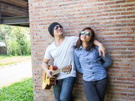 Young hipster man playing guitar to relaxing on his holiday, enjoy with natural and fresh air. photo