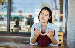 chica encantadora hipster relajándose en el parque mientras lee un libro, disfruta de la naturaleza. foto