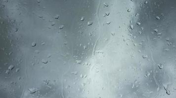 Time lapse rain drops in front of dark clouds on a glass window. video