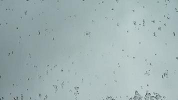 Hail running down a window during heavy weather. Melting ice time lapse video