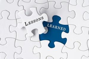 Lessons learned text on Jigsaw Puzzle over blue background. photo