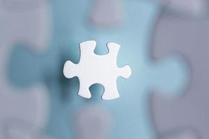Puzzle pieces isolated on blurred blue background. Flat lay. Directly above. photo