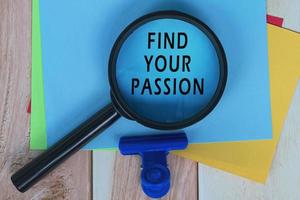 Find Your Passion on Blue Adhesive Note With Magnifying Glass On Wooden Desk. photo