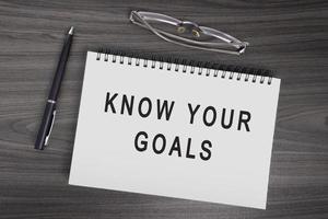 Know your goals text on notepad with pen, notepad and reading glasses. photo