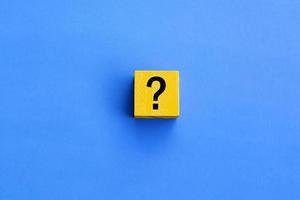 Cube with question mark on blue background. photo
