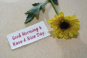 Motivational quote on torn white paper on wooden surface with sunflowers. photo