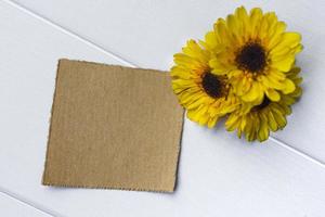 Torn brown paper on wooden surface and sunsunflower flat lay with copy space. photo