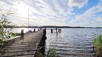 Beautiful sunset landscape with a wooden jetty at a small lake in northern Europe. video