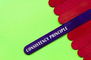 Consistency principle text on purple color wooden stick. Accounting concept. photo