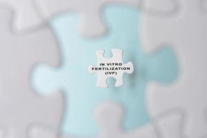 In Vitro Fertilization IVF word on puzzle pieces isolated on blue background. photo