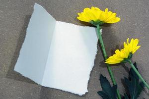 White paper on wooden surface and dahlia flower flat lay with copy space. photo