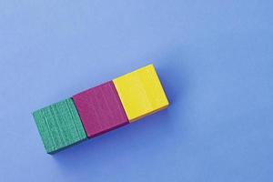 Colorful wooden cubes against blue background. Flat lay. Copy Space. Directly above. photo