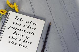 Motivational quote on note book with sunflowers on wooden desk. photo
