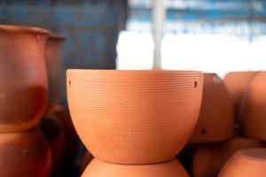 Stacks of orange various terracotta pots for plants for sale at a garden store. photo