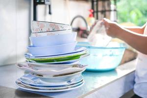 los platos se apilan para su limpieza en una cocina tradicional, cocina campestre, limpieza de platos y tazones. foto