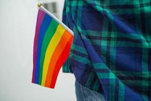 mujer asiática con bandera del arco iris, derechos del símbolo lgbt e igualdad de género, mes del orgullo lgbt en junio, lgbtq, lgbti, lgbtqa, lgbtqia foto