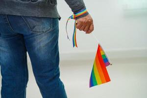 Asian woman with rainbow flag, LGBT symbol rights and gender equality, LGBT Pride Month in June. photo