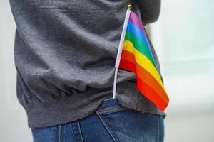 mujer asiática con bandera del arco iris, derechos de símbolos lgbt e igualdad de género, mes del orgullo lgbt en junio. foto