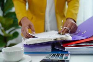 el empresario trabaja y prepara los datos del informe de papeleo para analizar la información en la carpeta de archivos en la oficina. foto