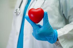 Asian woman doctor holding red heart for health in hospital. photo