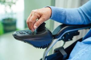 anciana asiática discapacitada paciente sentada en silla de ruedas eléctrica en el parque, concepto médico. foto