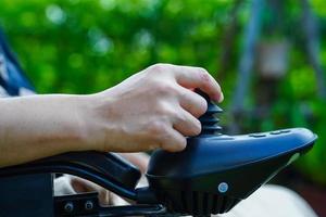 Asian elderly woman disability patient sitting on electric wheelchair in park, medical concept. photo