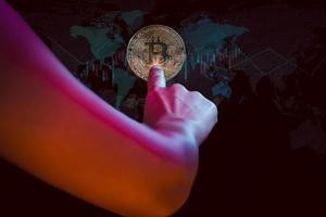 mano tocando el concepto de tecnología de negocios de modren de globo virtual de bitcoin. foto