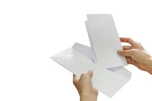 mujer mano poniendo carta en un sobre aislado en fondo blanco. foto