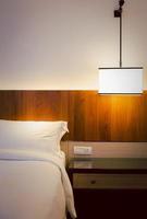Bedroom interior elements with stylish ceiling lamp on bedside table indoor. photo