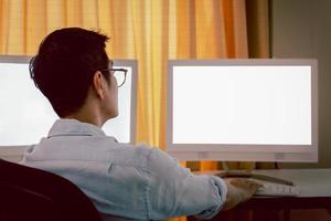 Businessman and eyeglasses working with charts and market reports on computer screens. photo