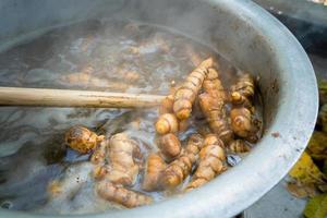 A close up shot of turmeric root being boiled in a big pot . Turmeric is a common spice that comes from the root of Curcuma longa. It contains a chemical called curcumin, which might reduce swelling.