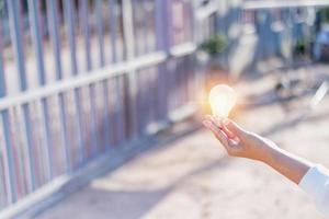 Female hand holding a shining light bulb, Great idea, innovation and inspiration, business concept background modern retro design photo