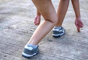 pies de corredor de atleta corriendo en la carretera, concepto de jogging al aire libre. mujer corriendo para hacer ejercicio. foto