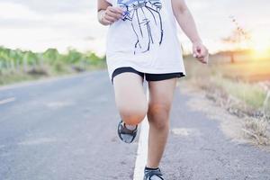 mujer trotando por la tarde o por la mañana, entrenando para descansar y recuperarse. foto