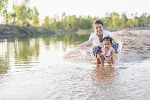 A young mother plays with her 2-5 year old daughter on the beach in summer. Outdoor resort on the lake Have a good rest on weekends, family days. photo