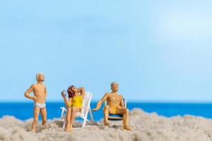 Miniature people Happy family relaxing on The beach photo