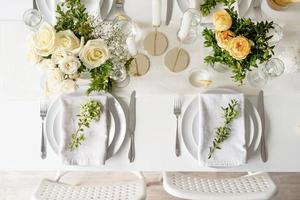 The wedding table setting, top view. Wedding teble decoration with white roses and boxwood photo