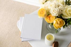 White book blank cover mockup on stylish chair with roses bouquet, high angle view photo
