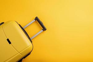 Top view yellow travel bag or suitcase on solid yellow background copy space. Tourist essentials photo