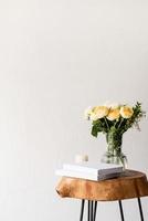 minimal home interior with stylish wooden coffee table and bouquet of fresh roses photo