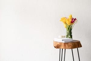 interior minimalista con una elegante mesa baja de madera y un ramo de tulipanes frescos foto