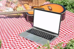 closeup of picnic place andlaptop with blank screen for mockup photo