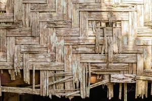 Old house wall made from pieces of bamboo , background. photo