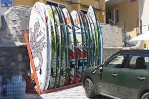 Yalta, Ukraine, July 26, 2021 - A set of soft boards for longboarding for extreme recreation and sports and a Mini Cooper car. photo