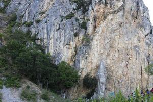 Crimea, Ukraine, July 25, 2021 - A group of children are engaged in rock climbing as a sport on the rocks in the Crimean mountains. photo