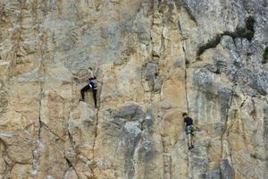 Crimea, Ukraine, July 28, 2021 - Extreme, rock climber on a sheer gray-red rock in the Crimean mountains. photo